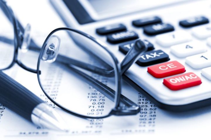 óculos e calculadora sobre uma mesa