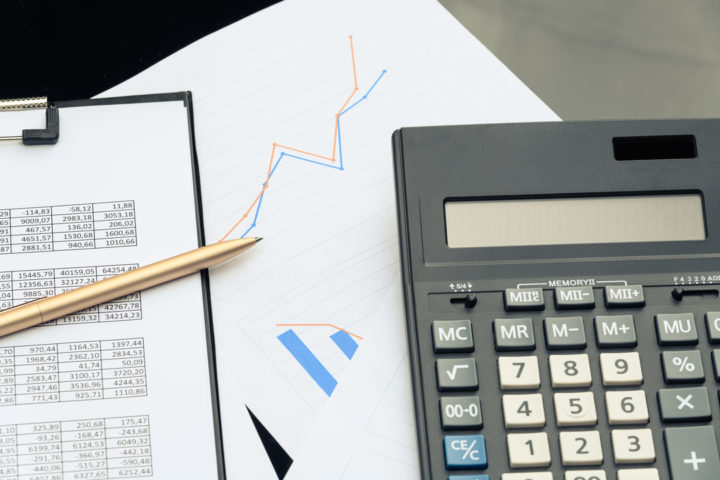 Papéis, caneta, gráficas, calculadora e planilha para calcular a bitributação